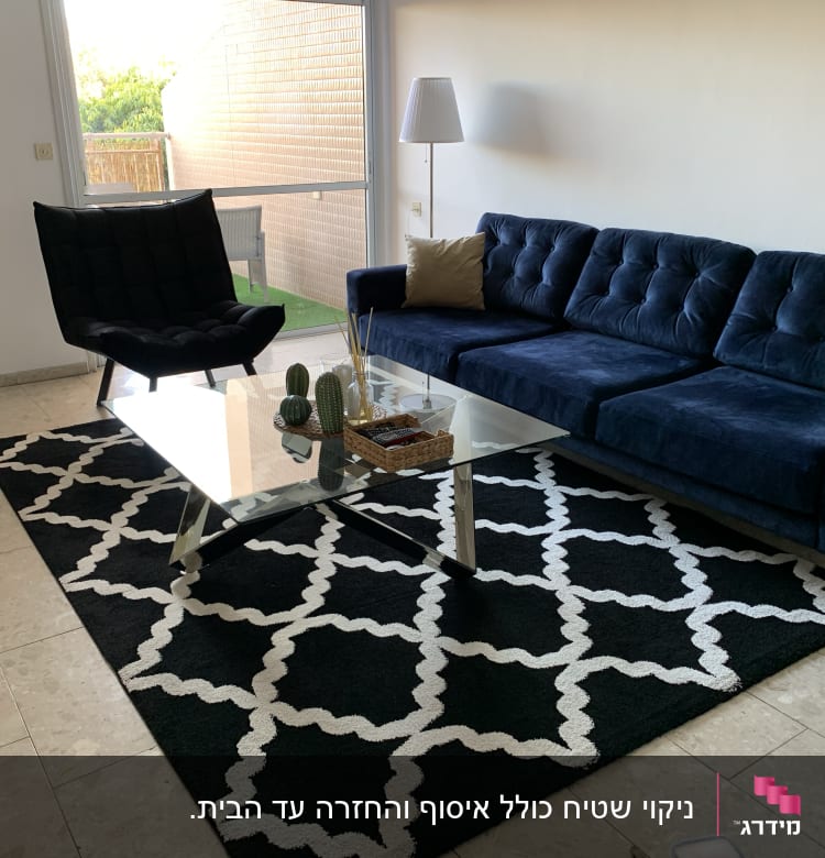 ספה כחולה עם כריות על שטיח שחור לבן